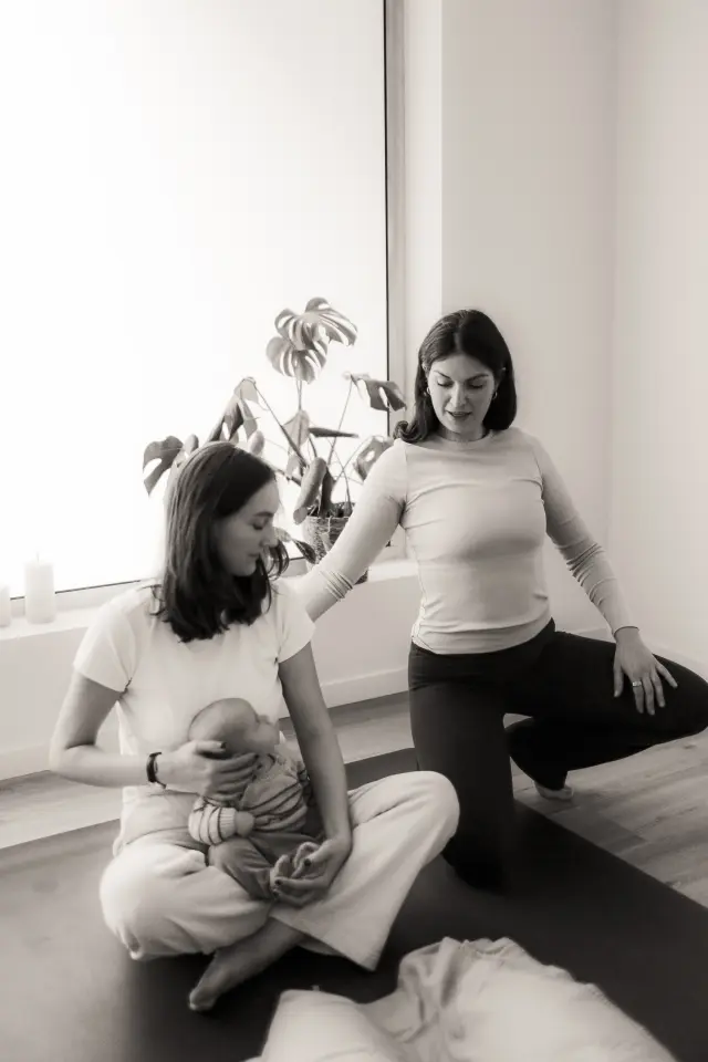 Julie guide une participante pendant une séance de yoga privée.