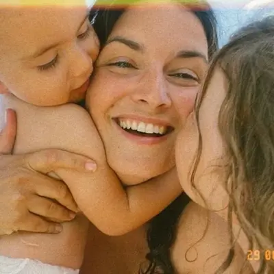 Julie enlacée avec sa famille, sourire complice.